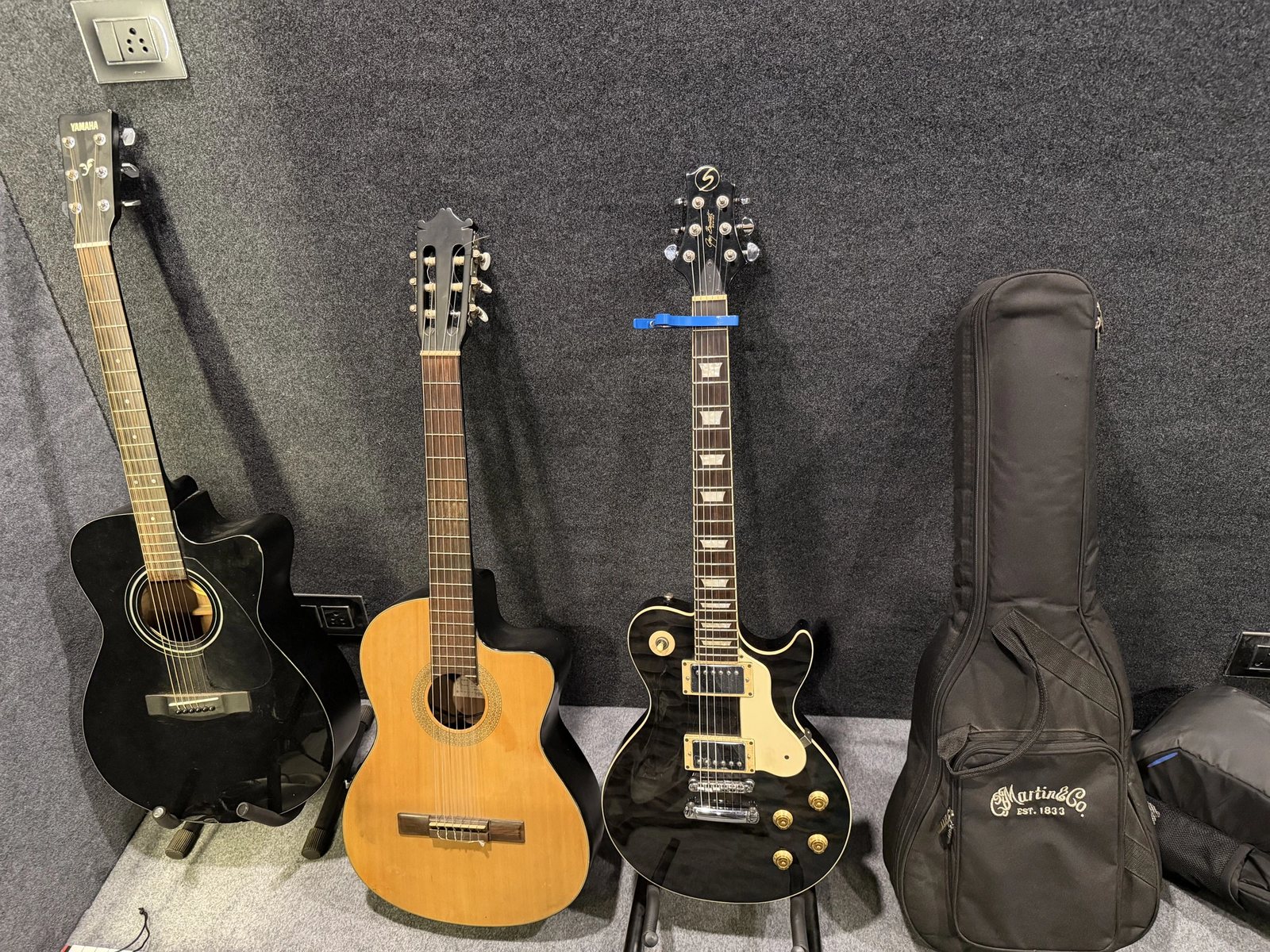 Acoustic, classical and electric guitars lined up against the acoustic treatment
